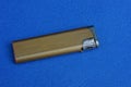brown  old open metal lighter lies on a blue table Royalty Free Stock Photo