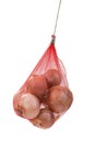 Brown onion hanging packed in a red net bag on white background