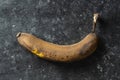 Brown overripe banana on black background. Closeup, top view