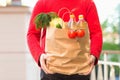 Brown paper bag with vegetables, in the hands of a man