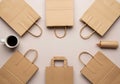 Brown paper bags are arranged in a circular pattern on a neutral surface. A white cup Royalty Free Stock Photo