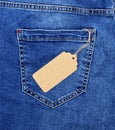 Brown paper blank price tag on rope against the back pocket of blue jeans Royalty Free Stock Photo