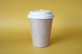 brown paper coffee mug on a yellow background. Empty space for text and design on a cup of coffee. The form for the name of the Royalty Free Stock Photo