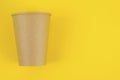 Brown paper drink glass disposable on yellow background