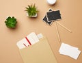 Brown paper envelope and empty wooden pointer on a brown background