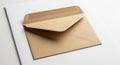 A brown paper envelope with a pointed flap is placed on a white surface. The Royalty Free Stock Photo