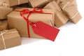 Isolated pile of brown packages, red gift label, copy space Royalty Free Stock Photo