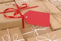 Red gift tag with several brown paper packages, copy space