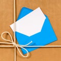 Brown paper parcel with blue envelope blank white label message card Royalty Free Stock Photo