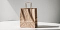 Brown paper shopping bag standing on a white surface with strong sunlight creating a shadow. Royalty Free Stock Photo