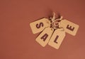 Brown paper tags with inscription sale on brown background, seasonal discount concept Royalty Free Stock Photo