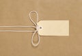 Brown paper background, parcel with string and plain manila label, copy space, horizontal Royalty Free Stock Photo