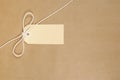 Brown parcel paper background, blank manila label tied with string, horizontal, copy space Royalty Free Stock Photo