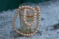 Brown pearl beads in a glass tumbler on white snow Royalty Free Stock Photo