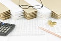 Brown pencil and pile of gold coins with spectacles Royalty Free Stock Photo