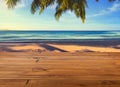 Brown plank wooden table or desk floor, perspective view, background of blurred landscape of summer beach, coconut leaves from Royalty Free Stock Photo