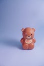 Brown Plastic bear piggy bank, isolated in blue background, studio shoot day time, valentine mood.