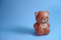 Brown Plastic bear piggy bank, isolated in blue background, studio shoot day time, valentine mood.