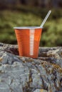 Brown plastic coffee cup with a spoon on a rock on a background Royalty Free Stock Photo