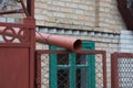 Brown plastic drainpipe on an iron mesh fence Royalty Free Stock Photo