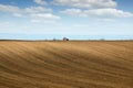 Brown plowed field and tractor