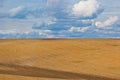 Brown plowed non-seeded field on a background of blue summer sky. sunny sky over an empty meadow. serenity, bliss. desktop Royalty Free Stock Photo