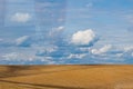 Brown plowed non-seeded field on a background of blue summer sky. sunny sky over an empty meadow. serenity, bliss. desktop Royalty Free Stock Photo
