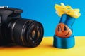 Brown, positive egg in clothes and a hat with a bow posing in front of the camera.on blue-yellow background, close-up