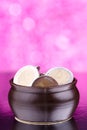 Brown pot with coins on pink background