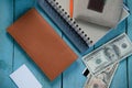 Brown purse with money, notebook and businesscard on the blue table Royalty Free Stock Photo