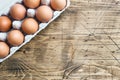 Brown raw eggs in factory packaging on rustic wooden background. Copy space Royalty Free Stock Photo