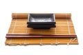 Brown rectangular plates, sandalwood wooden chopsticks and bamboo mat