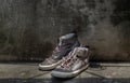 Brown Retro High Top Canvas Sneakers was placed on old cement floor. Vintage age-worn sneakers canvas shoes brown