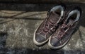 Brown Retro High Top Canvas Sneakers was placed on old cement floor. Vintage age-worn sneakers canvas shoes brown