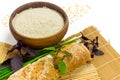 Brown rice flour in ceramic bowl, homemade rice bread, green onion and basil on sushi bamboo mat