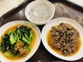 Brown rice porridge served with `Stir fried crispy pork with kale` and `Stir fried minced pork with salted Chinese black olive`.