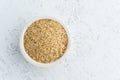 Brown rice in white bowl on white background. Dried cereals in cup, vegan food, fodmap diet. Top view, close up Royalty Free Stock Photo