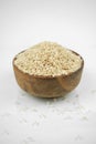 Brown rice in a wooden bowl isolated on white, vertical studio shot Royalty Free Stock Photo