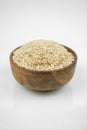 Brown rice in a wooden bowl isolated on white, vertical studio shot Royalty Free Stock Photo