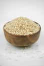 Brown rice in a wooden bowl isolated on white, vertical studio shot Royalty Free Stock Photo