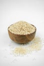 Brown rice in a wooden bowl isolated on white, vertical studio shot Royalty Free Stock Photo