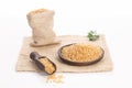 Brown rice on wooden plate and spoon , and burlap sack on white backround Royalty Free Stock Photo