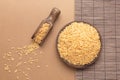 Brown rice on wooden plate and spoon, on brown and wood backround. Flat lay composition