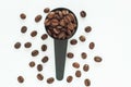 Brown roasted coffee beans in a black measuring spoon on a white background isolated Royalty Free Stock Photo