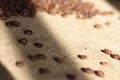 Brown roasted coffee beans are scattered on the burlap macro Royalty Free Stock Photo