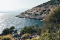 Brown rocks and sharp stones in the greenish blue water of Aegean sea near the shores of Demre city. Beautiful Turkish Royalty Free Stock Photo