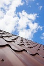 Brown roof of metal roofing on the sky background