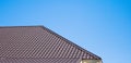 Brown roof of metal roofing on the sky background