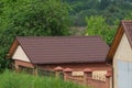 Brown roofs of buildings with tiles over a fence