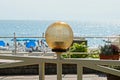 Brown round lantern on a gray metal fence against the background of the sea and sky Royalty Free Stock Photo